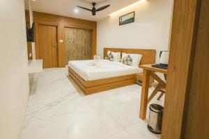 una camera da letto con un letto e una scrivania con un computer portatile di The Sky Imperial Unity Inn a Garudeshwar