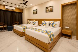 una camera d'albergo con due letti in una stanza di The Sky Imperial Unity Inn a Garudeshwar