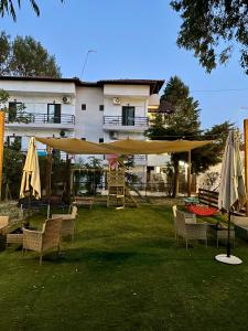 a group of chairs and umbrellas in front of a building at Star Country House in Ormos Panagias