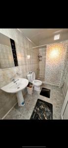 a bathroom with a sink and a toilet at Nur Guest House in Karakol