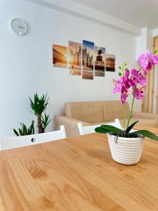 a vase of purple flowers sitting on a wooden table at CMcasevacanze in Milan +7 photos