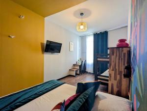 a bedroom with a bed and a tv in a room at Hôtel Des Arts, Artisanal et Indépendant in Montpellier