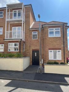 a brick apartment building with a black door at Seaview House with Sea View Brand New- 3 Bedrooms - Harwich, Dovercourt in Lancing