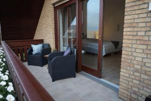 a patio with two chairs and a bed on a balcony at Ferienwohnungen Salz und mehr in Bad Sassendorf