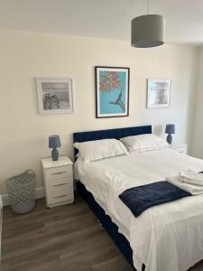a bedroom with a large bed with a blue headboard at Seaview House with Sea View Brand New- 3 Bedrooms - Harwich, Dovercourt in Lancing