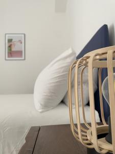 a white bed with white pillows and a rattan chair at Ca' Semu in Catania +26 photos