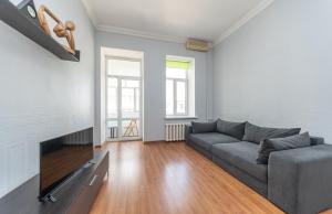 a living room with a couch and a flat screen tv at Простора квартира біля Майдану Незалежності in Kyiv