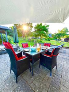 a patio table with chairs and a table with a bowl on it at Landhaus AUSZEIT in Borod