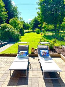 two white chaise lounges sitting on a patio at Landhaus AUSZEIT in Borod