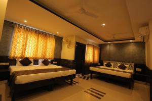 a hotel room with two beds and curtains at Nakshatra Hotel in Bānswāra