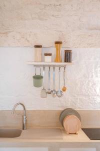 - un comptoir de cuisine avec des ustensiles sur une étagère au-dessus d'un évier dans l'établissement Suite Oronzo By PREGIO VILLAS, à Ostuni 32 autres photos