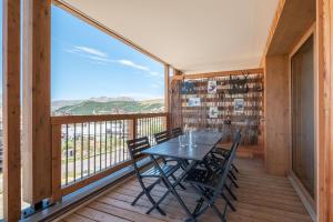 una sala da pranzo con tavolo e sedie su un balcone di Apartment Vallejo Alpe D'Huez - by EMERALD STAY a LʼHuez