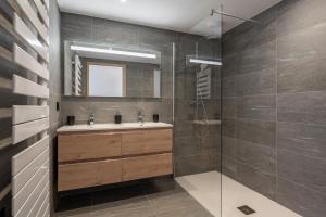 un bagno con lavandino e doccia di Apartment Vallejo Alpe D'Huez - by EMERALD STAY a LʼHuez