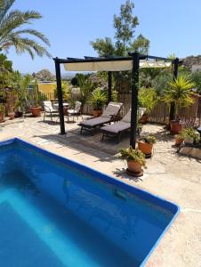 a swimming pool with a gazebo and a patio at Nick's Cave, Bed and Breakfast with a difference in Cuevas del Almanzora
