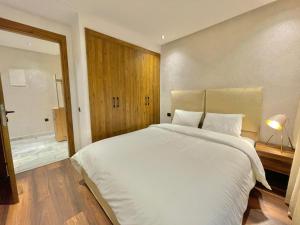 ein Schlafzimmer mit einem großen weißen Bett und einem Fenster in der Unterkunft D1115 Studio au Cœur de Casablanca Proximité et Confort1 in Casablanca