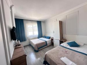 a hotel room with two beds and a television at Nazar Hotel in Trabzon