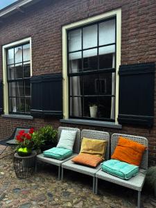 a bench with pillows sitting in front of a building at Casa Elburg in Elburg