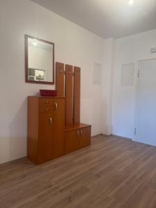 a room with a wooden dresser and a mirror at Apartman Kovač in Posušje +2 photos