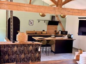 a large kitchen with wooden beams and a table at Loft élégant au cœur de la campagne avec SPA privé in Mauvezin