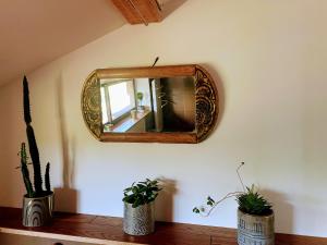a mirror on a wall with two potted plants at Loft élégant au cœur de la campagne avec SPA privé in Mauvezin