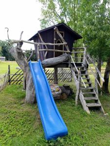 a blue slide next to a tree house at suur saunaga puhkemaja in Kipi