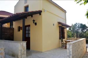 a patio of a house with a wooden door at Hidden Gem at Kiani Beach in Kalyves