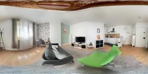 a living room with a couch and a tv at T2 avec beaucoup de cachet in Saint-Quentin