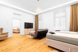 Zimmer mit 2 Betten, einem Stuhl und einem TV in der Unterkunft Lé David City Apartments 1020 in Wien