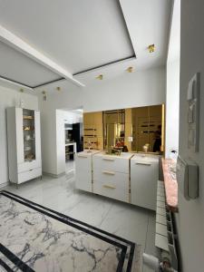 a large kitchen with white cabinets and mirrors at Willa Apartament Prestige z sauną i siłownią na wyłączność in Żołynia