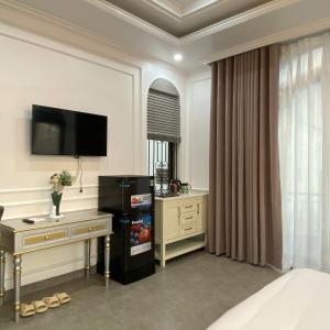 a hotel room with a bed and a desk and a television at Eco Bliss Hotel in Thôn Lại Thê +73 photos