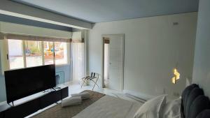 een slaapkamer met een groot bed en een flatscreen-tv bij Tao chambre in Taormina