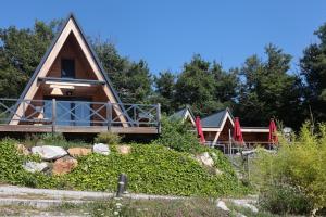 Saint-Christo-en-JarezにあるÔ TIPI LODGEの背景の木々が茂る丘の上の家