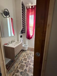 a bathroom with a sink and a toilet and a window at Villa Marcelle in Evisa