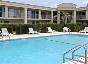 Una piscina con sillas y un hotel. en Studio 6 Ocala, FL, en Ocala