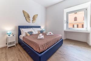 Un dormitorio con una cama azul y una ventana. en Anna Bijoux - Vatican City & Metro Ottaviano, en Roma