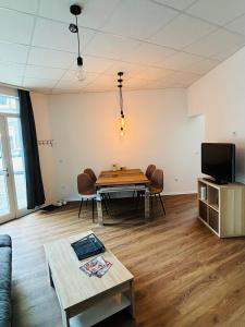 a living room with a table and chairs and a tv at Top Appartement in Bremerhaven