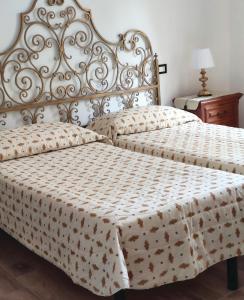 a bedroom with two beds and a table with a lamp at Domus Pisana in Pisa