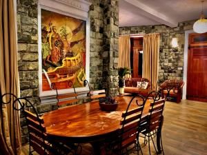 a dining room with a wooden table and a painting on the wall at Diyon Holiday Bungalow in Bandarawela