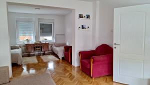 a living room with two red chairs and a table at Apartman Maja in Srbobran