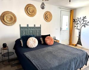 a bedroom with a blue bed with pillows on it at Studio , gîte 1, confortable et calme au millieu des vignes in Moussan