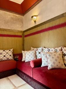 a red couch in a room with pillows on it at Riad la Cigale in Marrakesh
