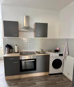 a kitchen with a stove and a washing machine at Moderne Wohnung Bitterfeld in Bitterfeld +14 photos