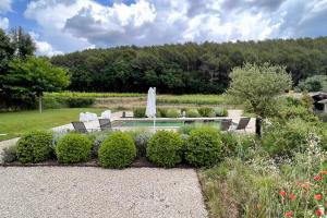 einen Garten mit Pool und einigen Büschen in der Unterkunft Maison des Vignes Swimming pool and charm in Lauris in Lauris