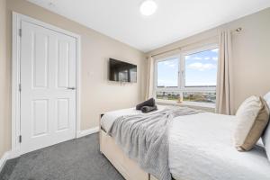 a bedroom with a bed and a window at Modern 5 Bedroom Townhouse with Free Parking in Glasgow