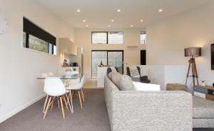 een woonkamer met een bank en een tafel bij Highland Views in Queenstown