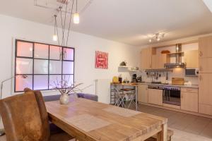 a kitchen and dining room with a wooden table at Casa Rolando in Nördlingen