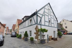 a white and black building with potted plants on a street at Casa Rolando in Nördlingen