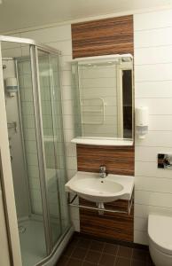 a bathroom with a sink and a shower at Ulvsvåg Gjestgiveri og Fjordcamping AS in Ulvsvåg