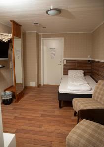a small room with a bed and a couch at Ulvsvåg Gjestgiveri og Fjordcamping AS in Ulvsvåg