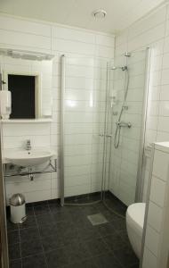 a bathroom with a shower and a sink and a toilet at Ulvsvåg Gjestgiveri og Fjordcamping AS in Ulvsvåg
